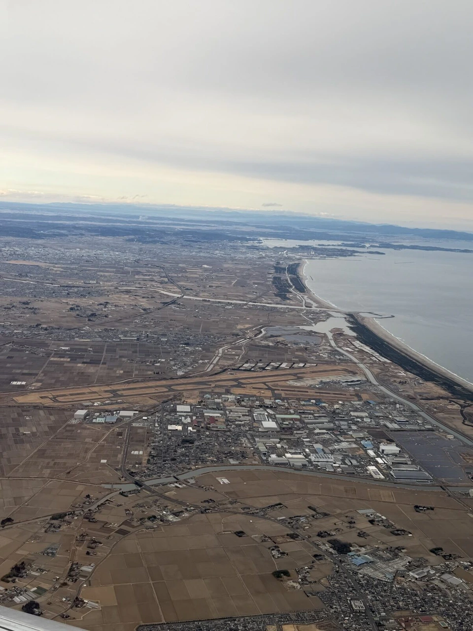 仙台湾沿いにまっすぐ北へ続く海岸線と、その内側に広がる平野と町