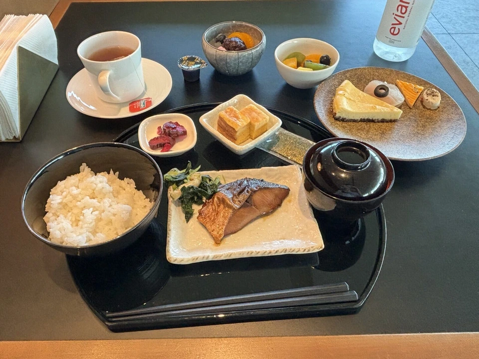 黒いお盆に載った和朝食と、別皿のチーズケーキと和菓子