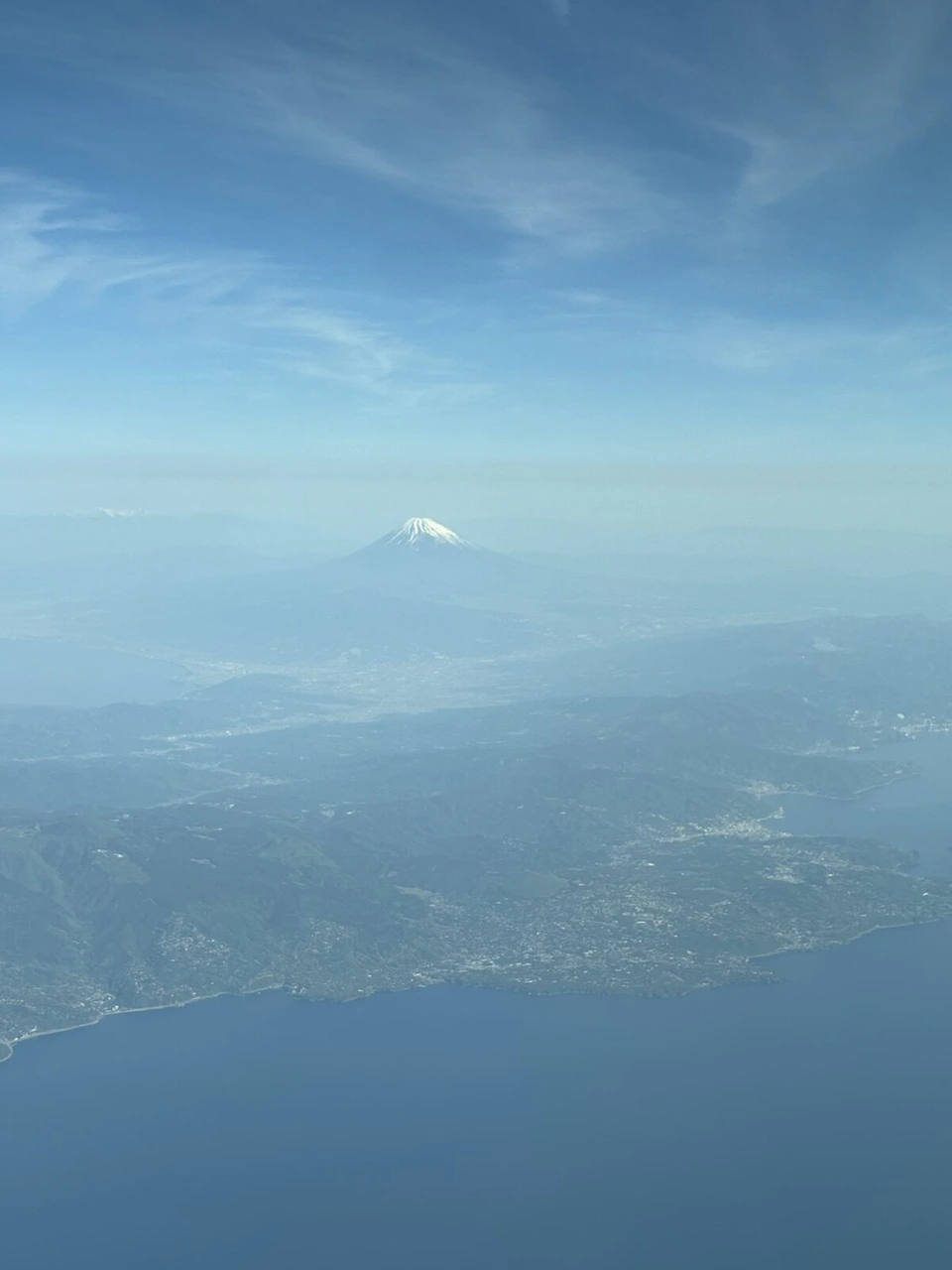 海と半島の向こうに頂上だけ白い富士山
