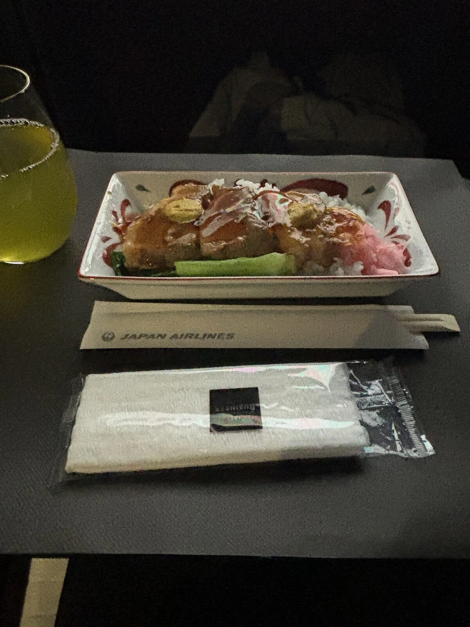 JL12の2回目の食事。JAPAN AIRLINESの箸袋と、肉と紅しょうがの載った丼、緑茶