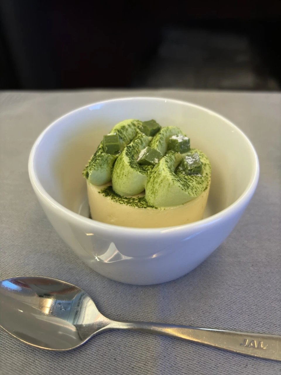 抹茶のクリームと粉がかかったデザートのアップ