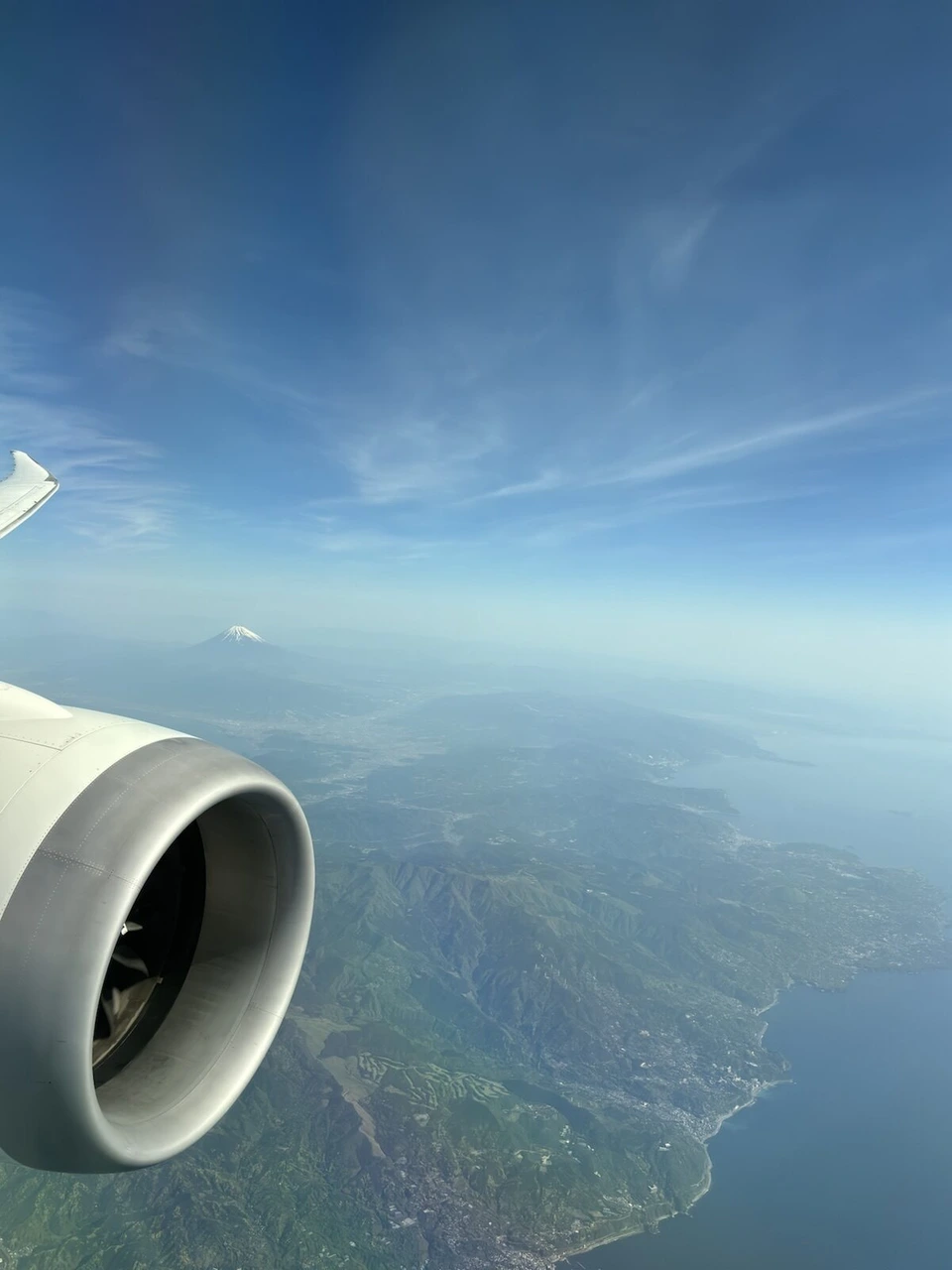 JL102の機窓から見た伊豆半島の海岸線と、奥に小さく見える富士山