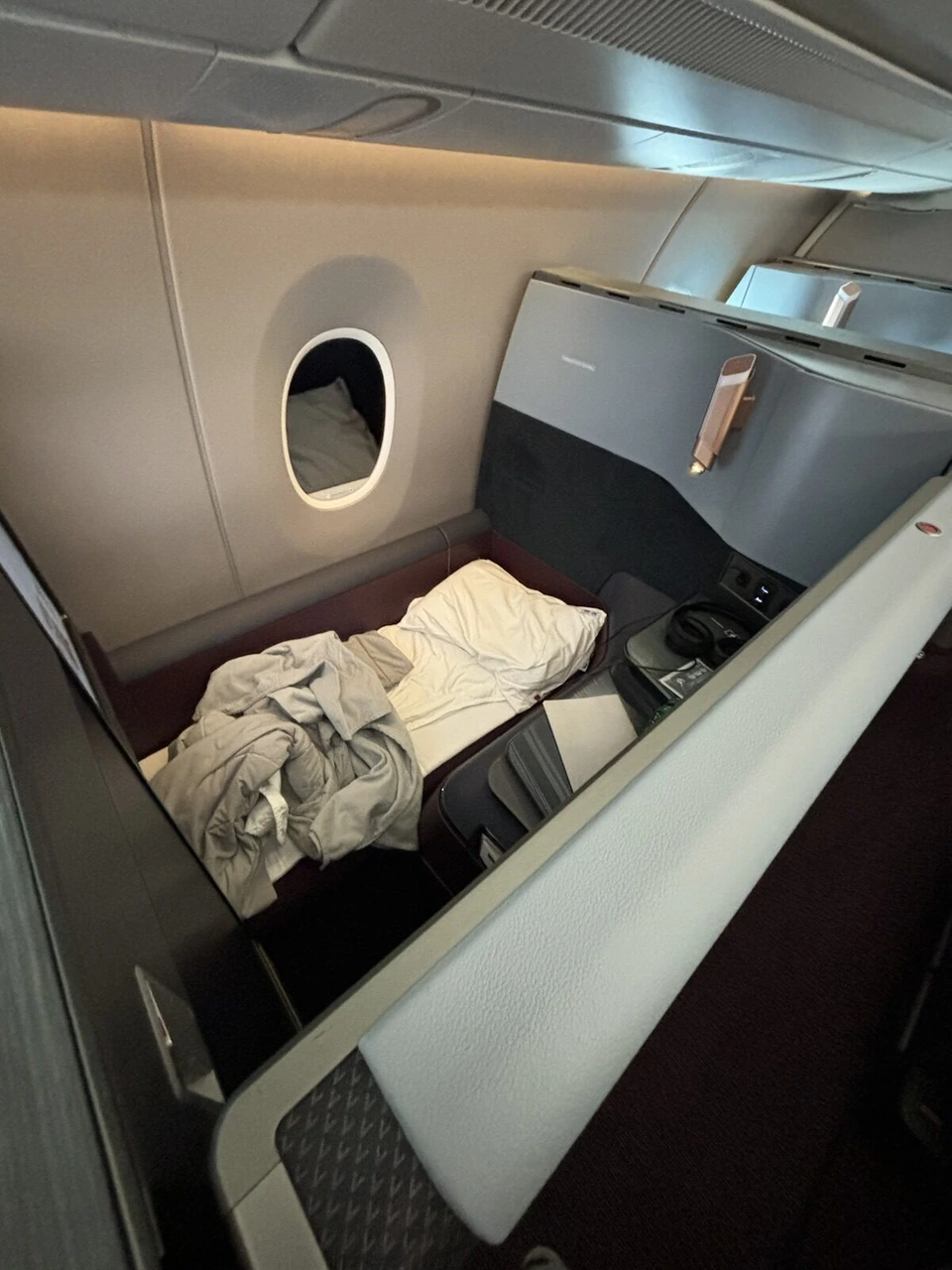 フルフラットにしたJAL A350-1000ビジネスクラスの座席に敷かれたマットと布団