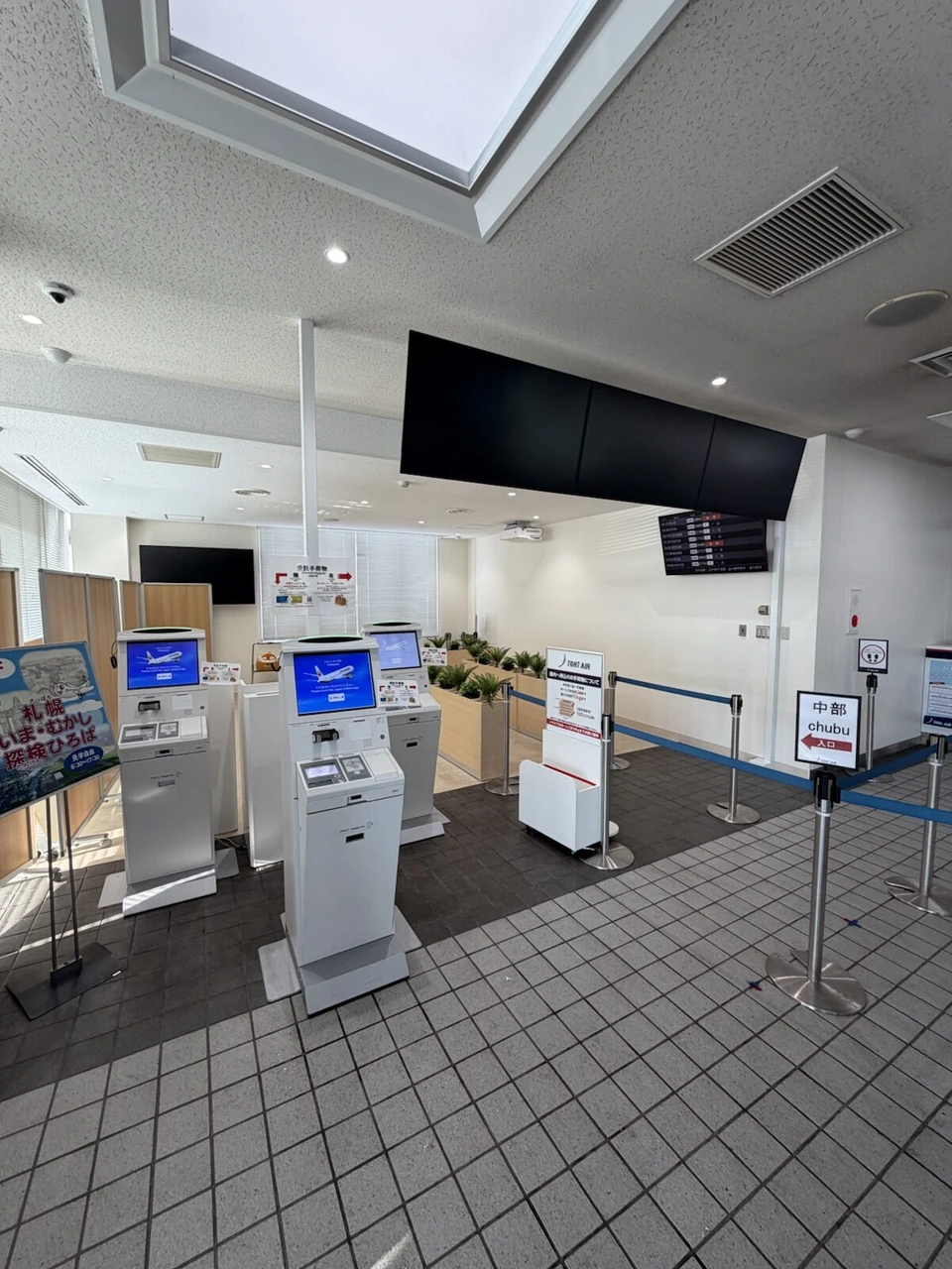 丘珠空港の出発ロビー。JALの自動チェックイン機と、トキエアの中部行きの案内