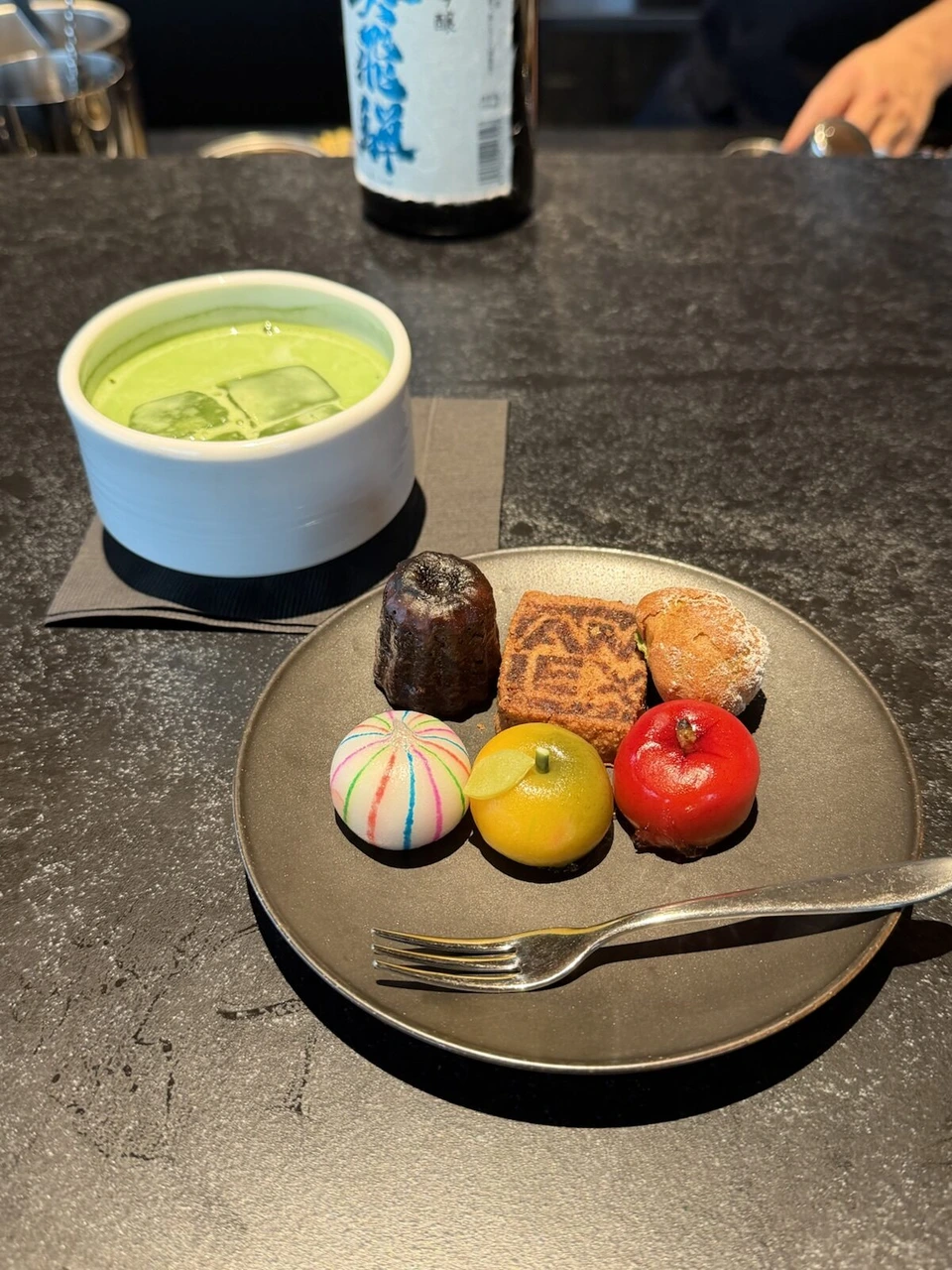 JALのラウンジのバーカウンターの抹茶ラテと、カヌレや和菓子をのせたプレート