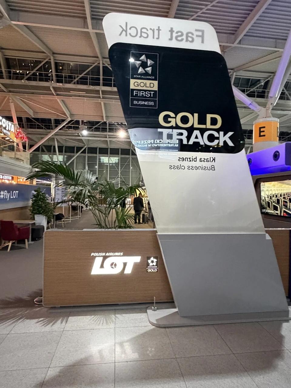 ワルシャワ・ショパン空港のGOLD TRACKの看板。STAR ALLIANCE GOLD、FIRST、BUSINESSの表示とLOTのロゴ