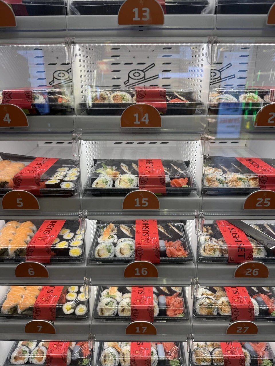 ワルシャワ・ショパン空港のお寿司の自動販売機。番号付きの棚に巻き寿司のパックが並ぶ