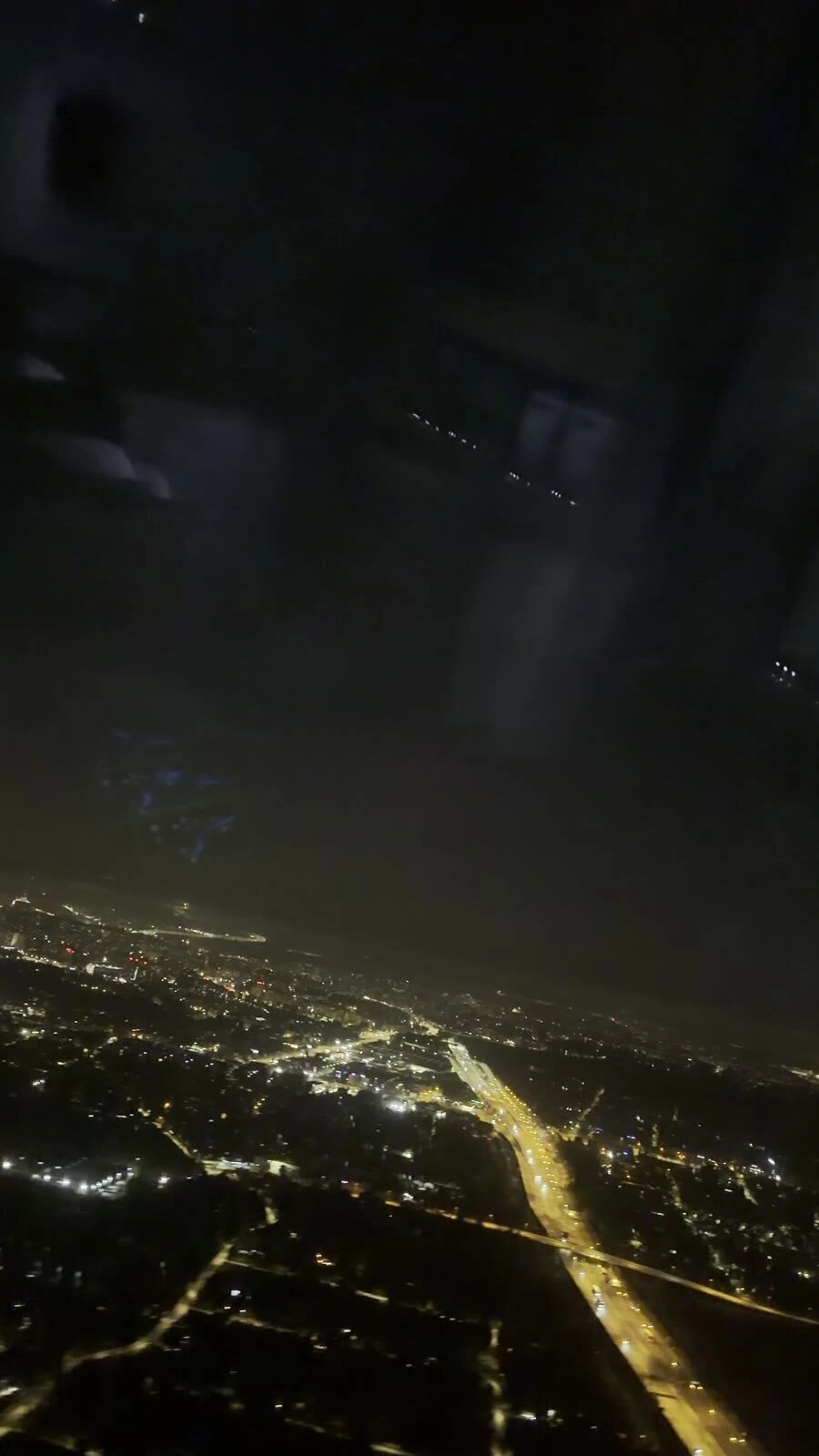 離陸直後の窓から見たワルシャワの夜景。高速道路の明かりと街の光
