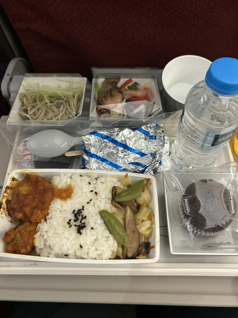 MH052の機内食トレーを別の角度から。サラダとアルミホイルのパン