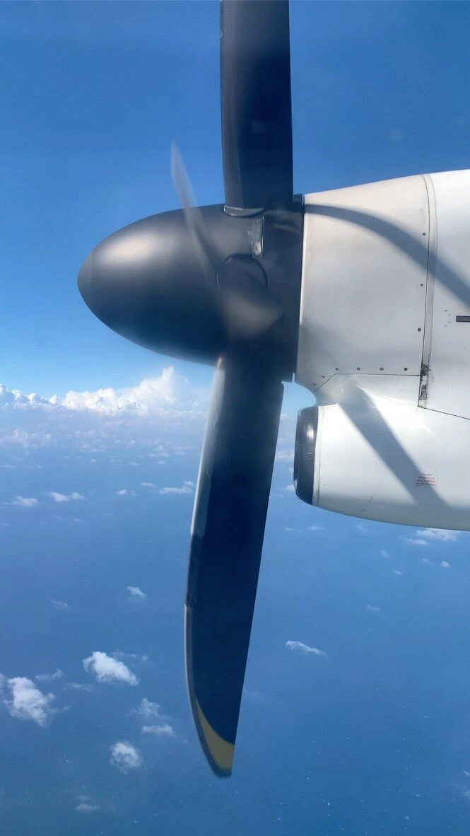RAC745便(DHC8-Q400CC)の窓から見えるプロペラと青い空