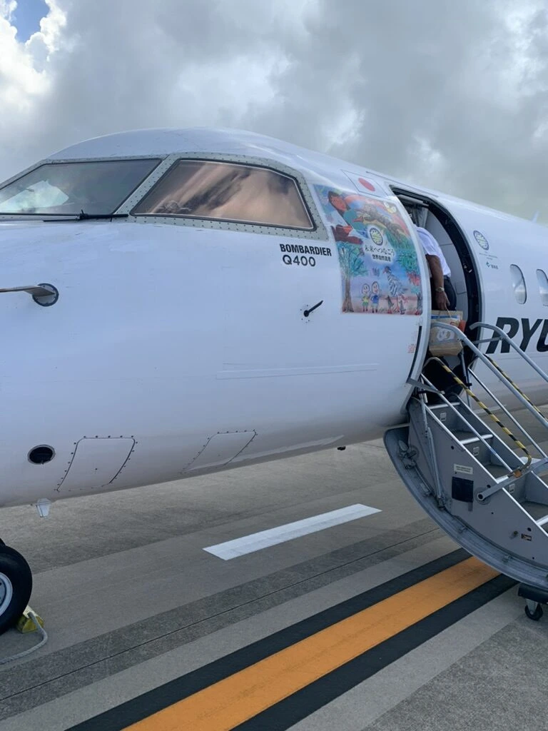 RAC機の機首とドアのタラップ。BOMBARDIER Q400の表記と、子どもの絵のステッカー