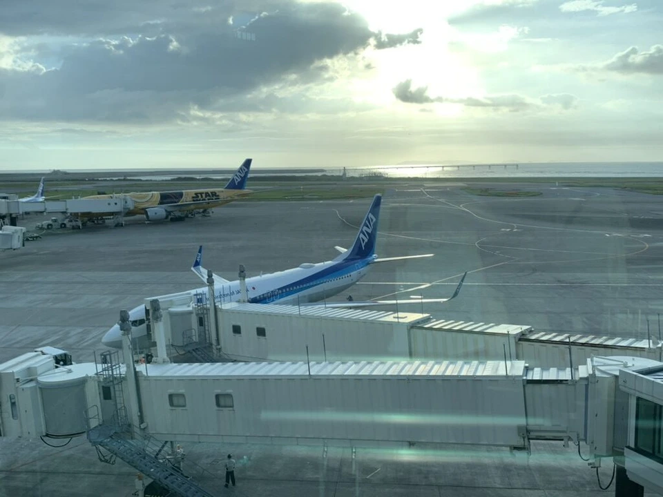 那覇空港の窓から見た夕方の駐機場とANAの機体、ボーディングブリッジ
