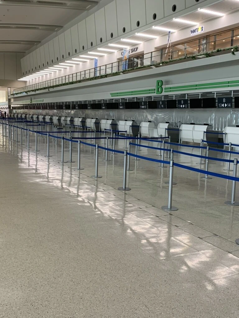 人のいない那覇空港のチェックインカウンターと誘導ロープ