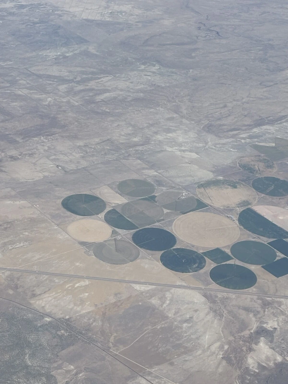 スピリット航空の機窓から見た砂漠の中の円形の農地