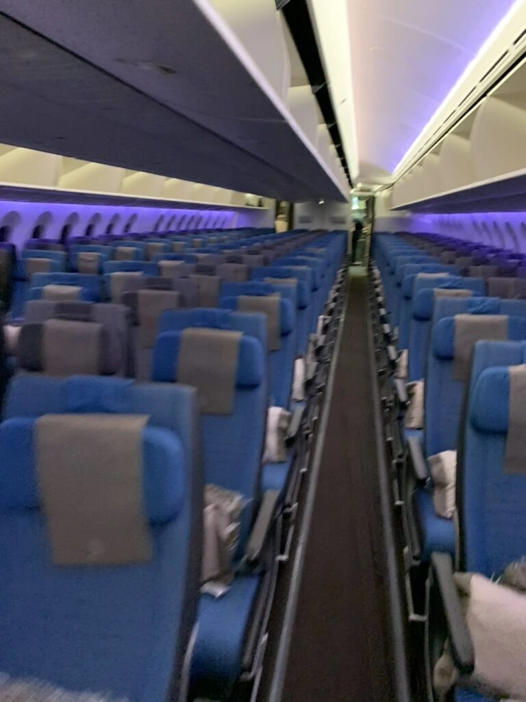 SQ618の787-10のエコノミー客室。青い座席が並び、まだ乗客は少ない