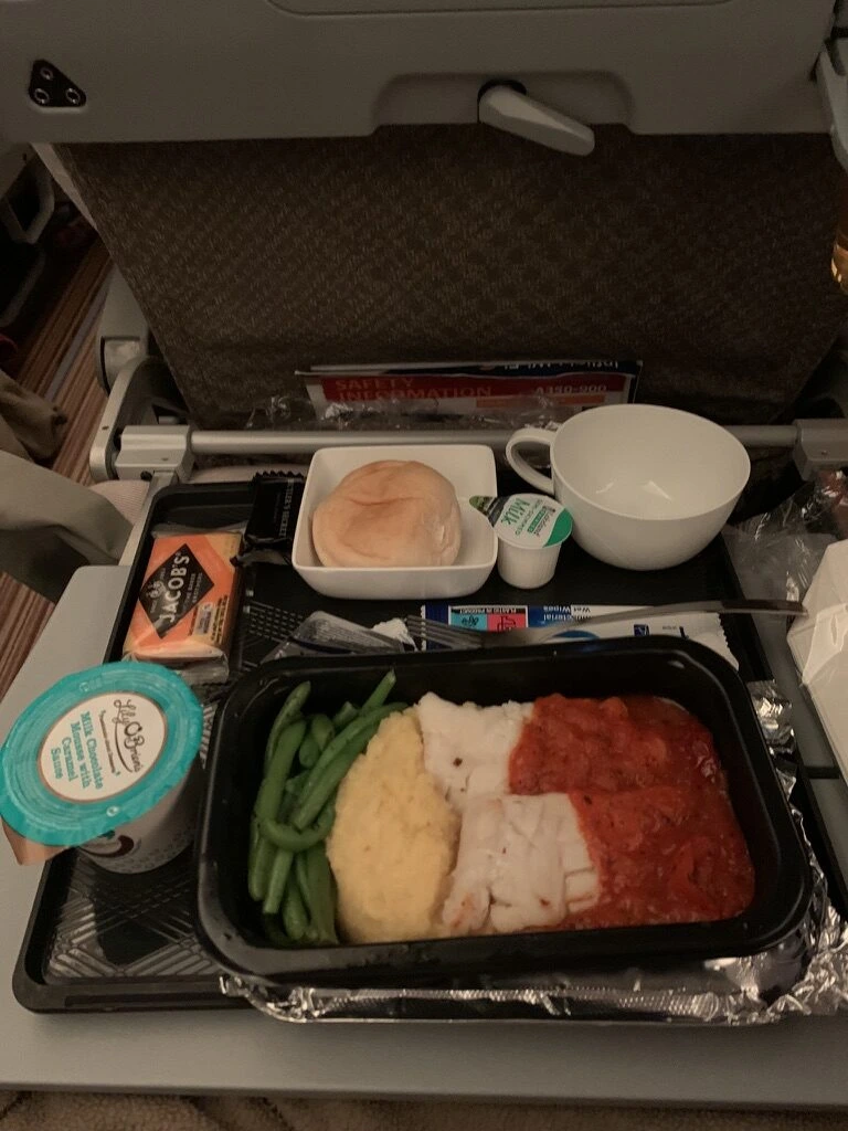 SQ321のエコノミーの機内食トレー。タラのトマトソース、ポレンタ、インゲン、パン、クラッカー
