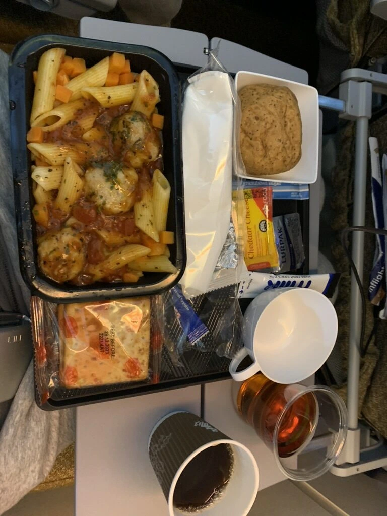 SQ332 エコノミーの機内食トレー。トマトソースのペンネ、パン、チーズとクラッカー、デザート、飲み物