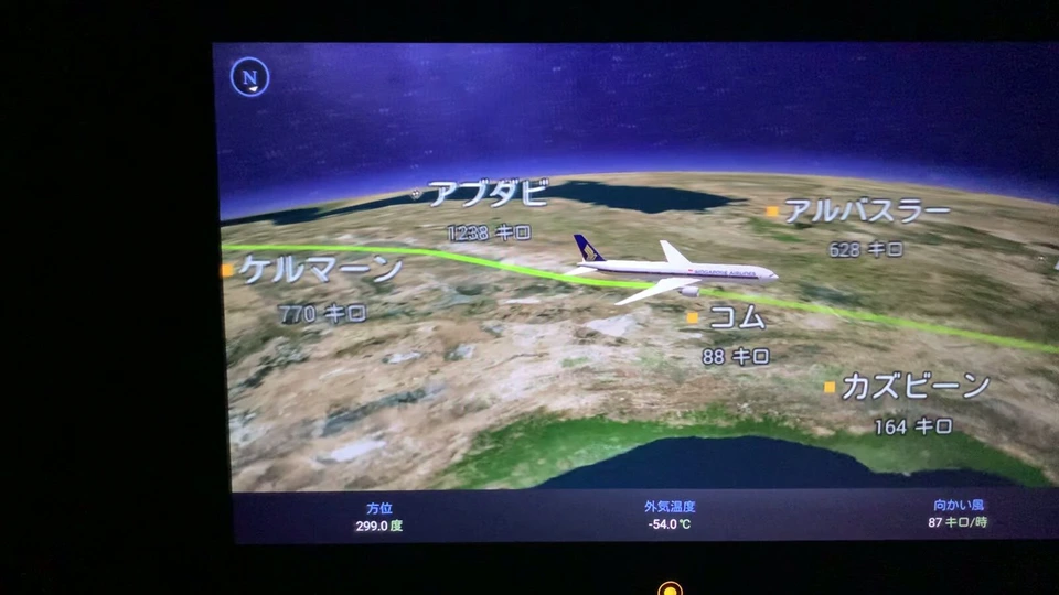 機内エンタメの3D地図。シンガポール航空の機体がコムの近くを飛び、カズビーン、ケルマーン、アブダビの名前と距離が出ている