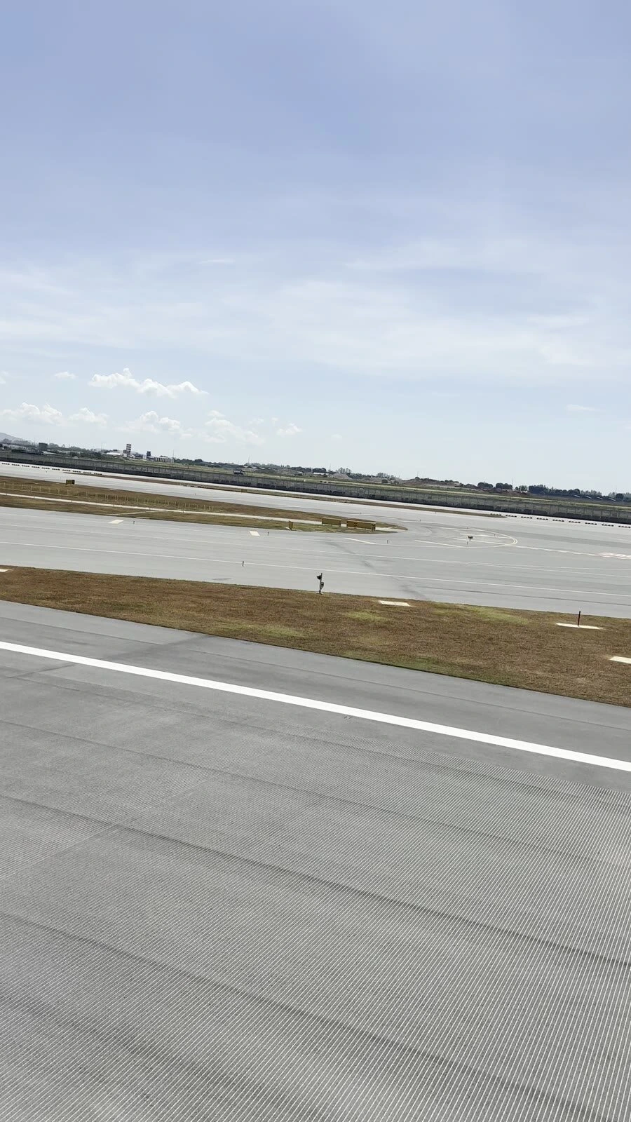SQ900の機窓から見たチャンギ空港の滑走路と芝生