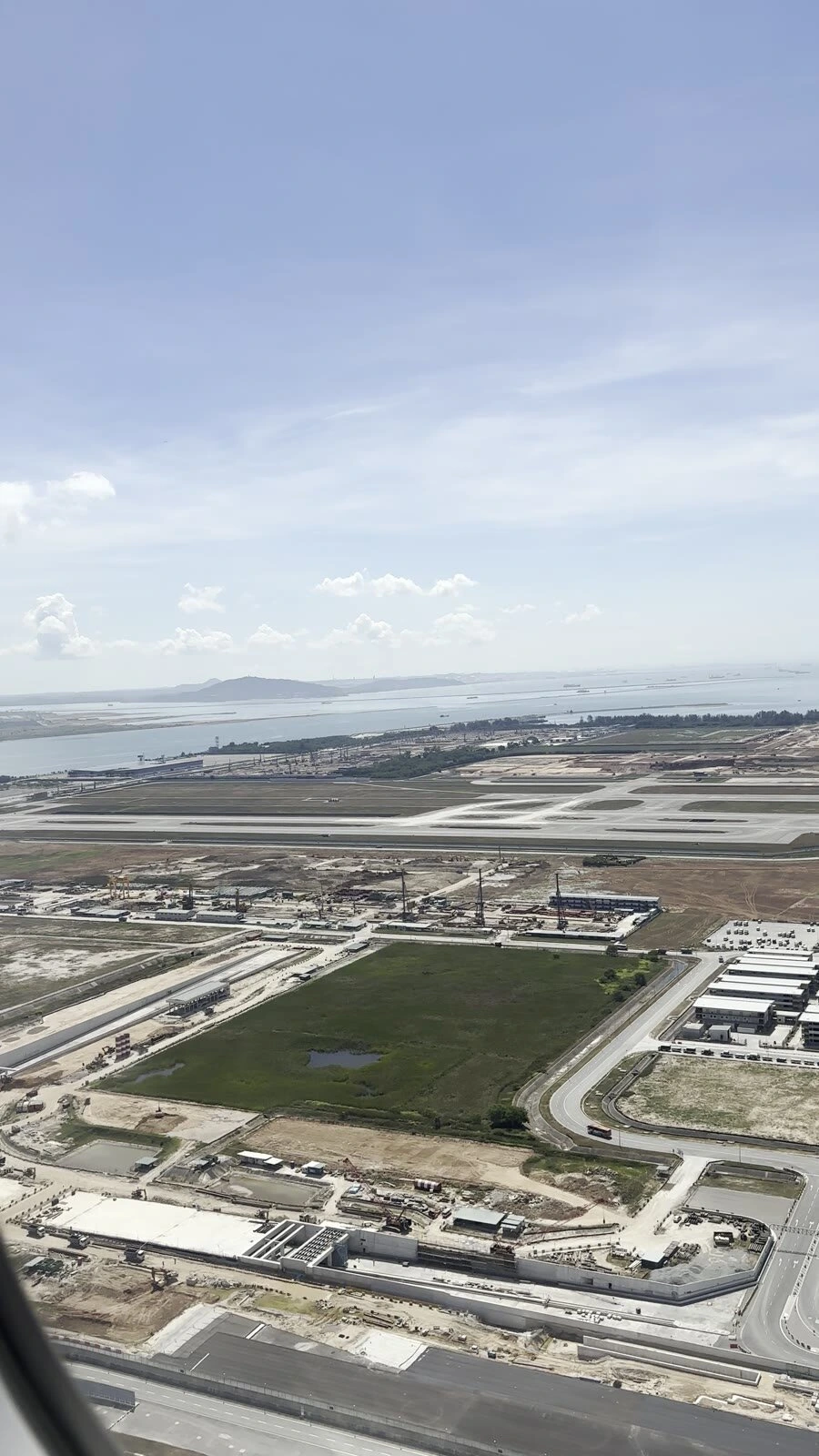 離陸直後の機窓から見下ろしたチャンギ空港の周りの造成地と海