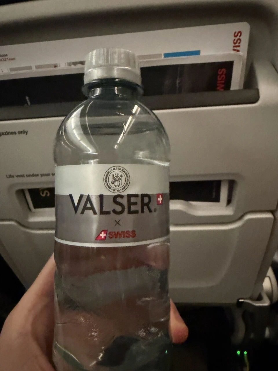 手に持ったVALSERの水のペットボトル。ラベルにSWISSのロゴ