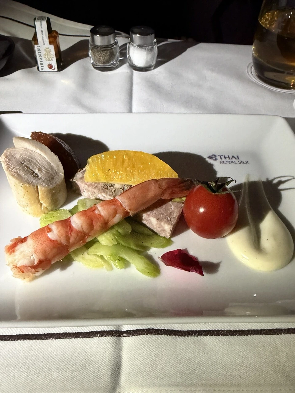 前菜のアップ。大きなエビ、テリーヌ、ロール状の肉、ミニトマト