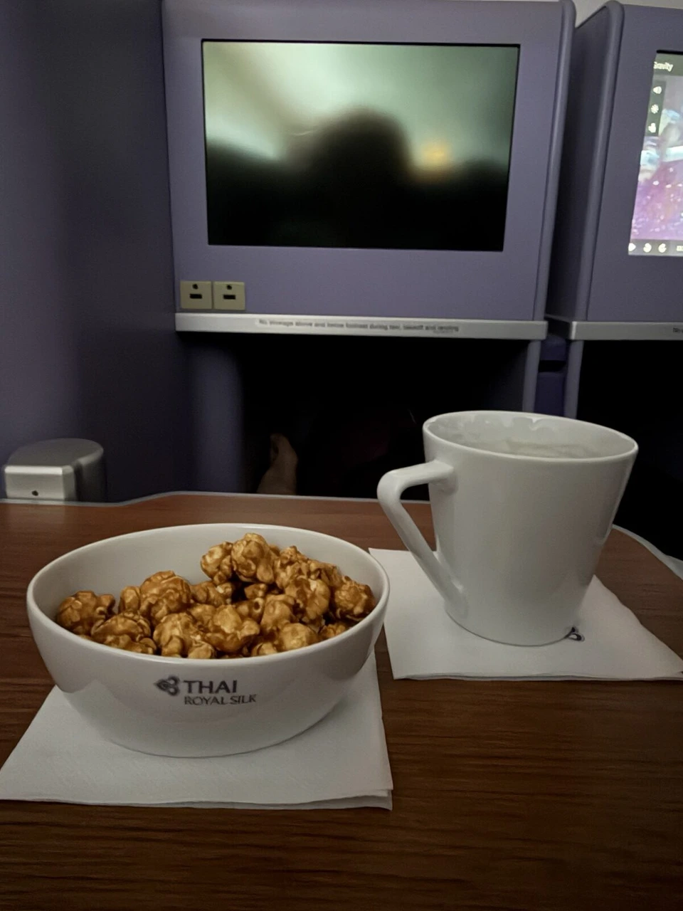 THAI ROYAL SILKのロゴ入りの器に入ったキャラメルポップコーンとコーヒーカップ