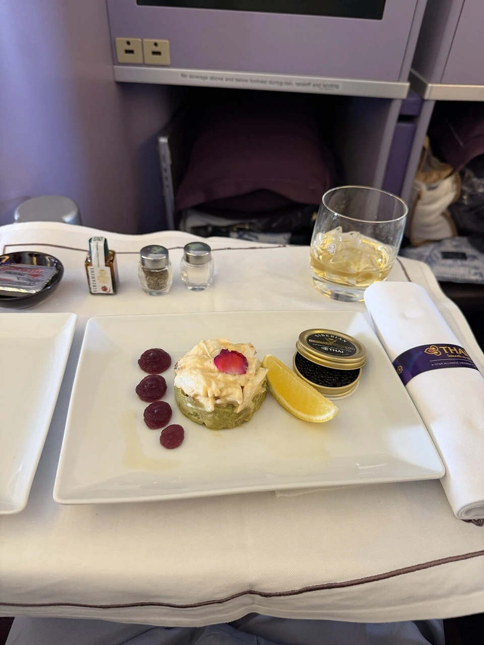 前菜の皿と塩・こしょう、ナプキン、グラスの飲み物が並んだテーブル