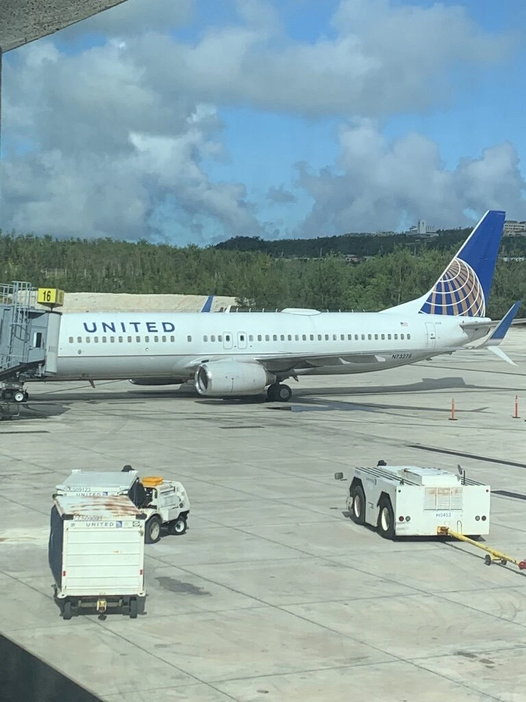 グアム空港に駐機するユナイテッド航空のボーイング737と地上車両
