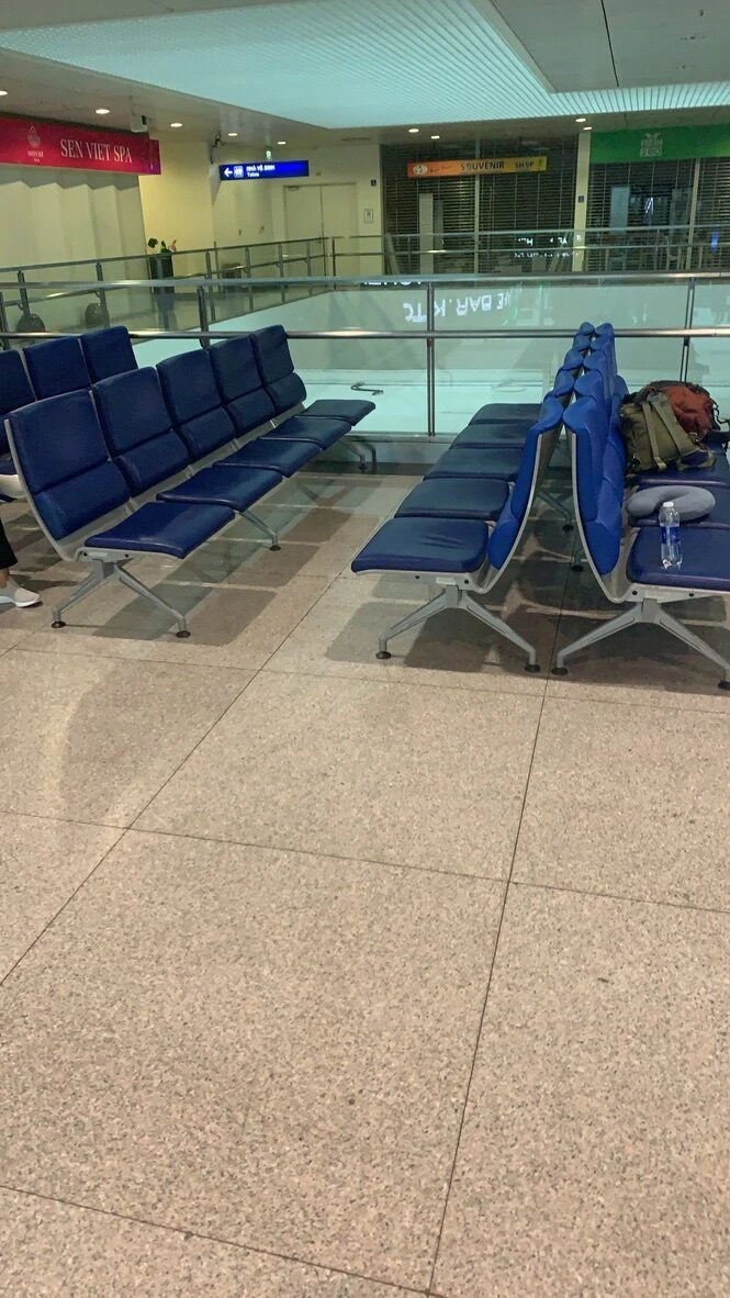 タンソンニャット空港の人の少ない出発エリアの青いベンチ