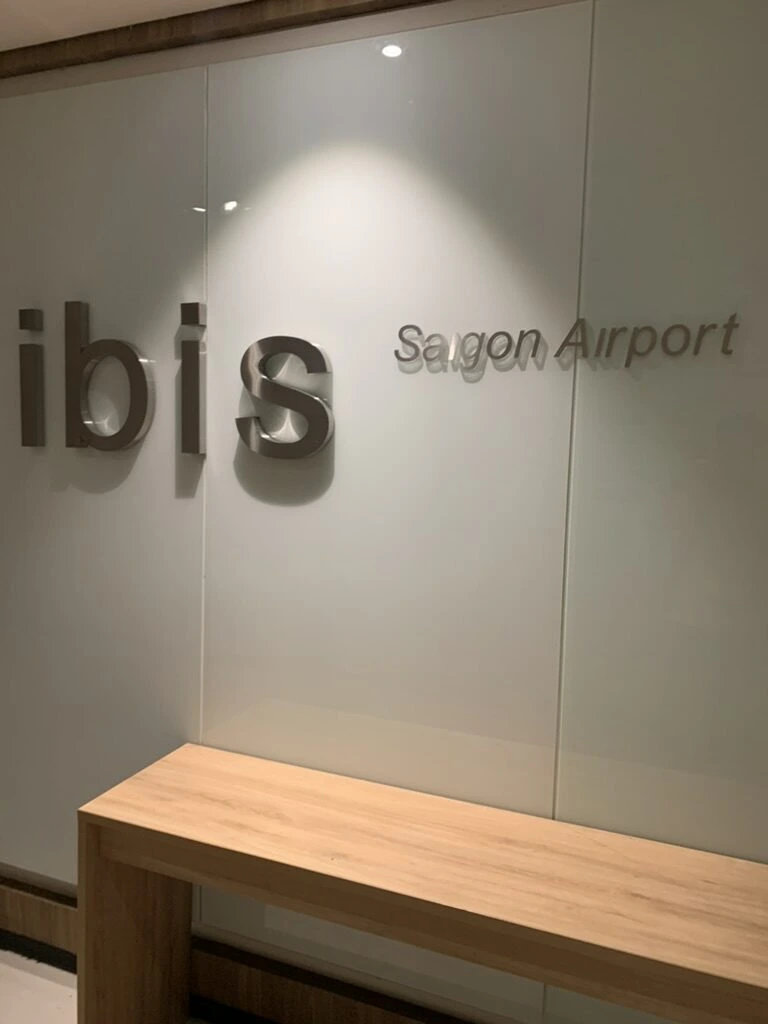 ホテルの壁に掛かるibis Saigon Airportのロゴ
