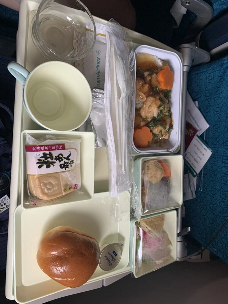VN321の機内食トレー。あんかけのおかずがのったご飯、パン、小鉢、粒あん最中
