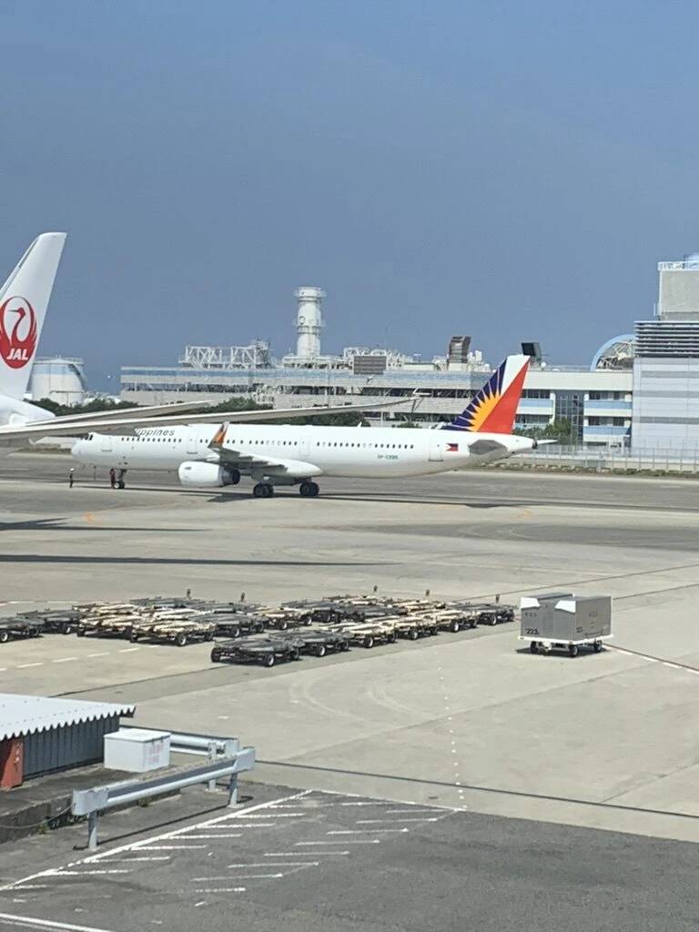 関空のエプロン。JALの尾翼とフィリピン航空のA321