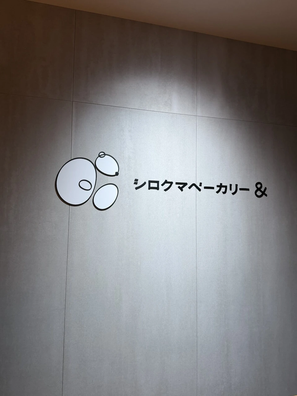 AOAO SAPPOROの館内の壁に照らされた「シロクマベーカリー&」のロゴ