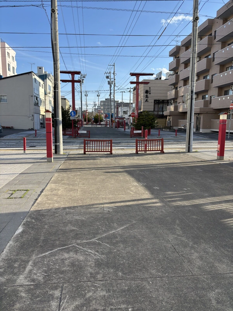 旭川駅の東の住宅地の通りに並ぶ赤い鳥居と赤い柵