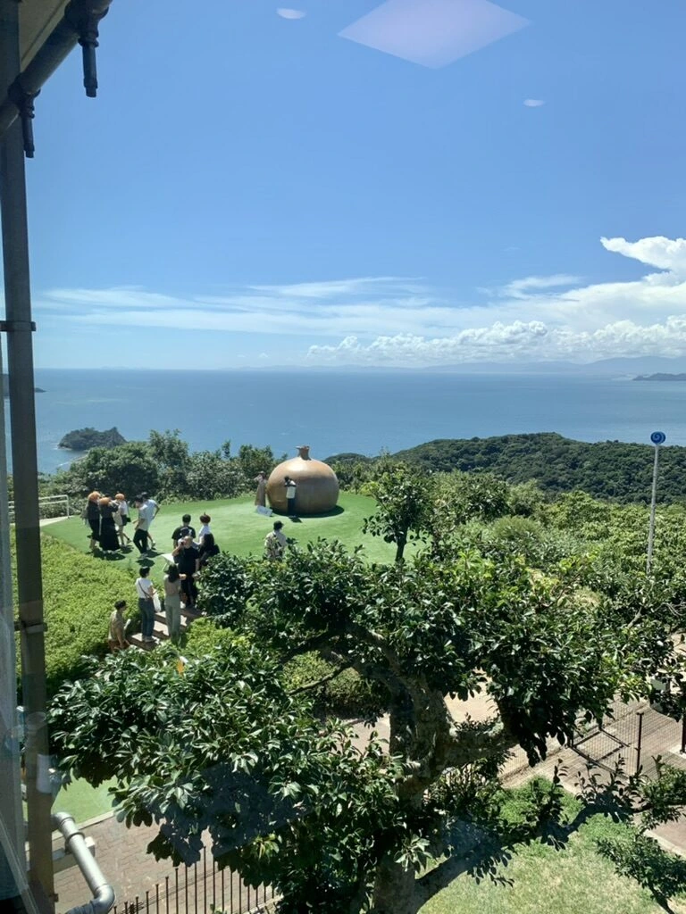 絶景レストラン うずの丘の窓の柱越しに見た芝生広場と海
