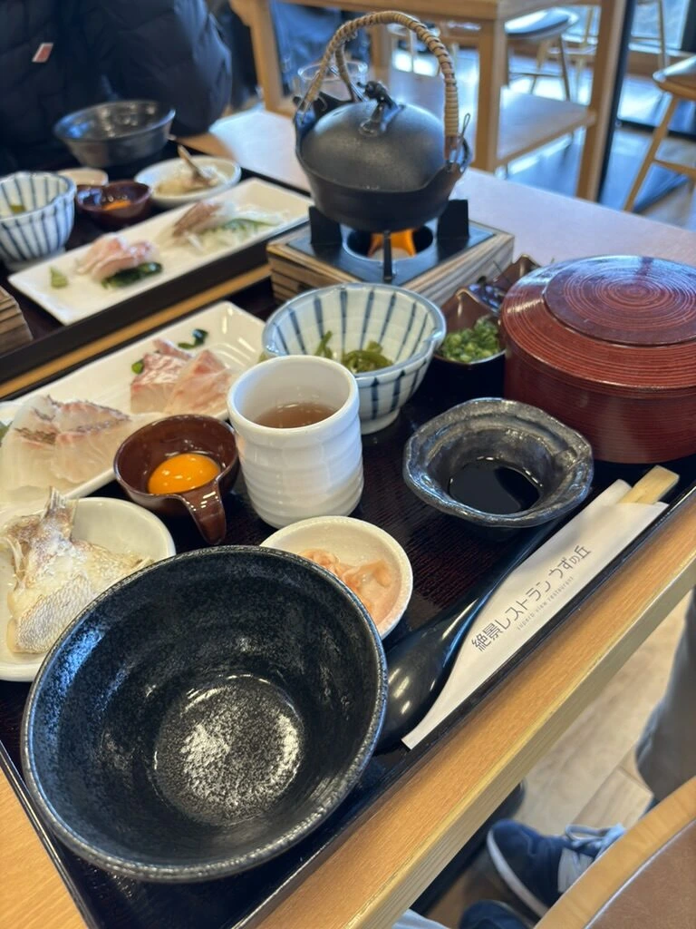 絶景レストラン うずの丘の2024年1月の御膳。鯛の刺身、卵黄、小鉢、鉄瓶、赤いお椀