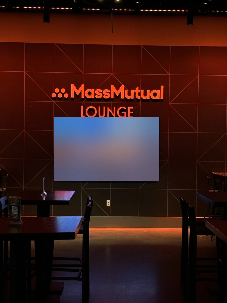 MassMutual Loungeのオレンジ色の壁とロゴ、次の公演を映す画面