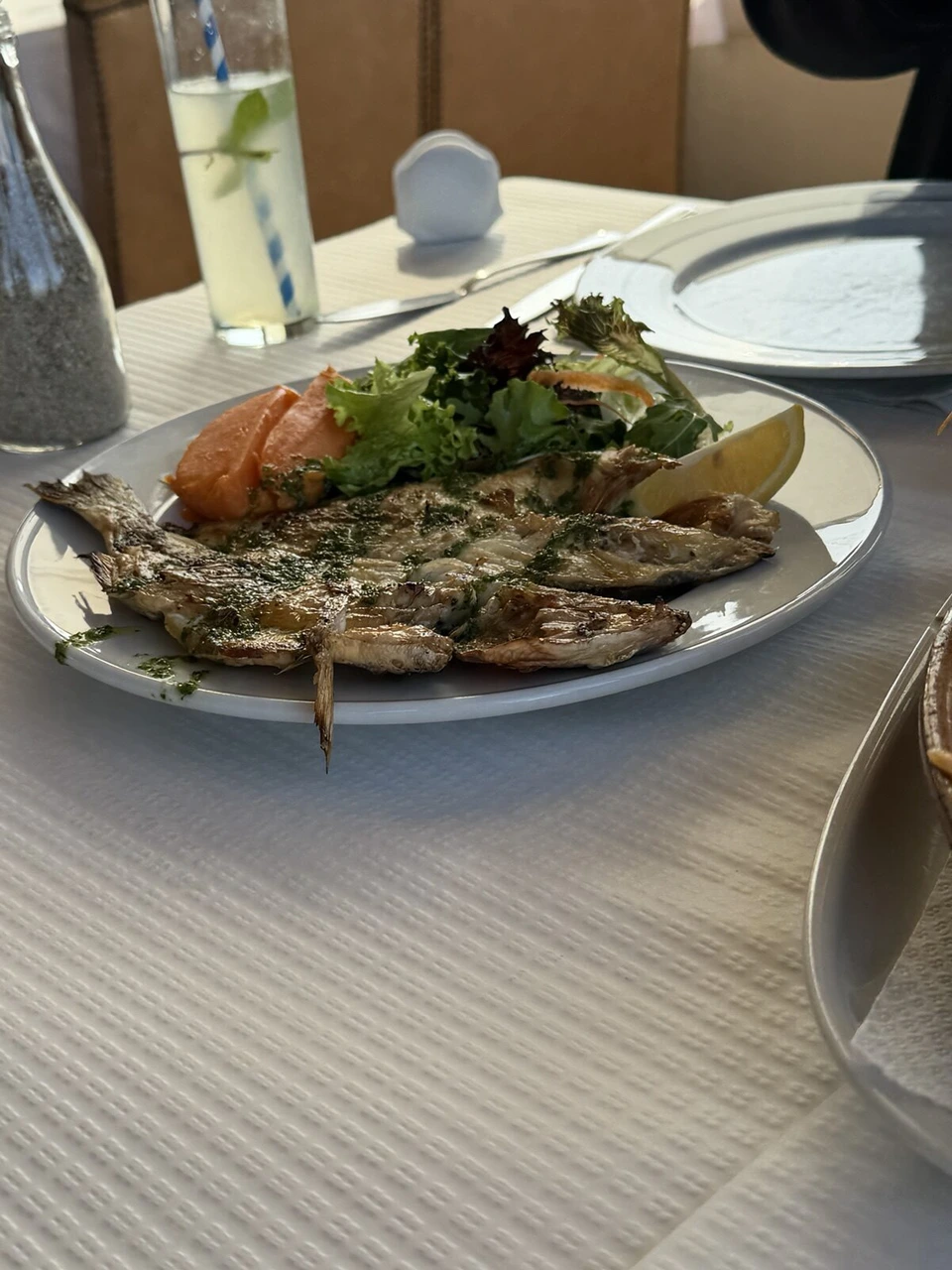 ハーブをのせた焼き魚と、サラダとレモン