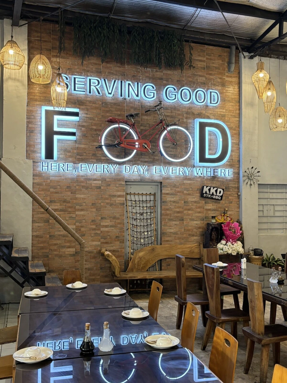 セブ旧市街のレストランの店内。SERVING GOOD FOODのネオンサインと飾られた自転車