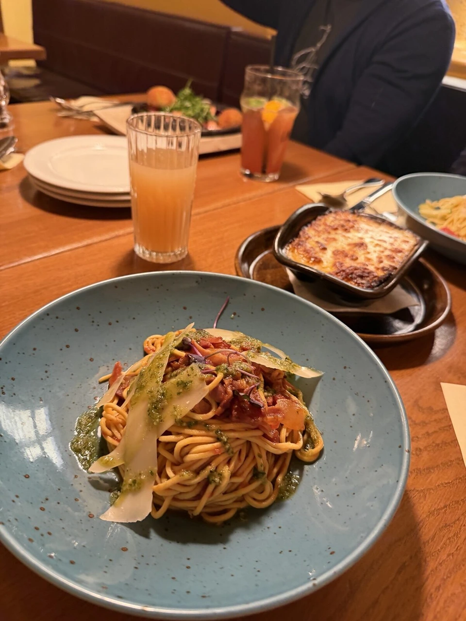 テーブルに並んだパスタとグラタン、グラスの飲み物