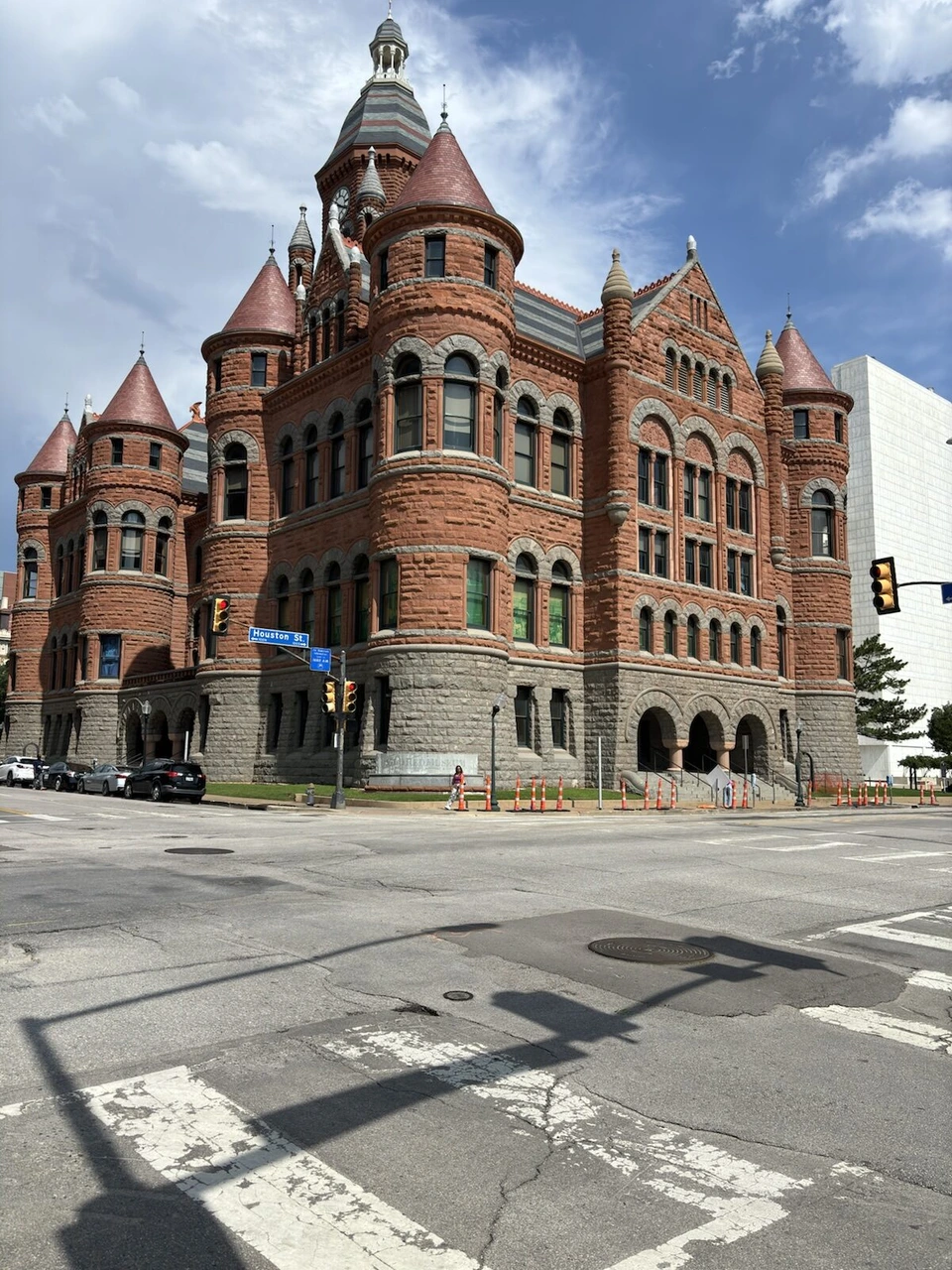 交差点の向こうに建つ赤い砂岩の旧ダラス郡庁舎オールド・レッド。とんがり屋根の塔がいくつもある