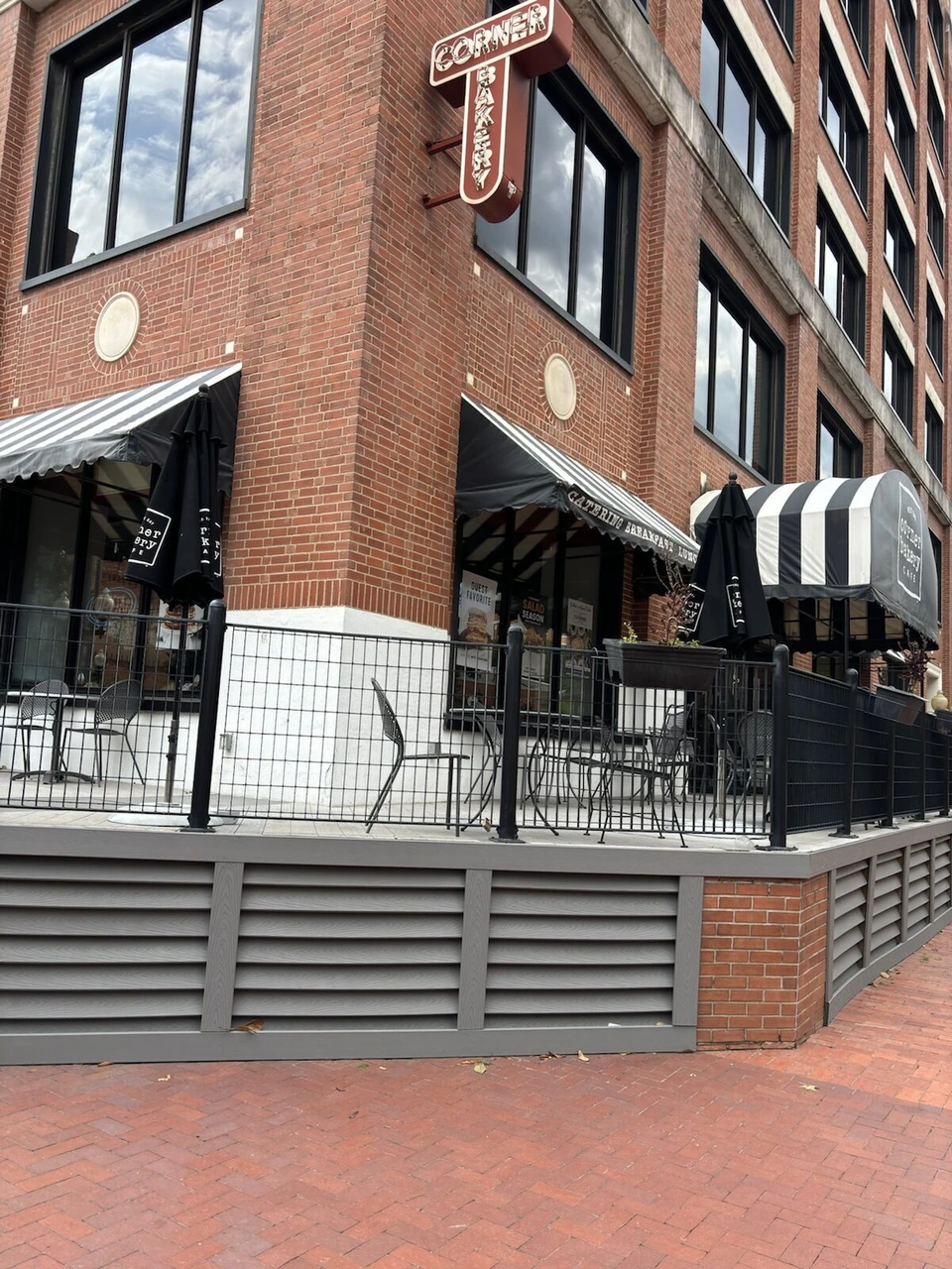 れんがのビルの角にあるCorner Bakery Cafeのテラス席