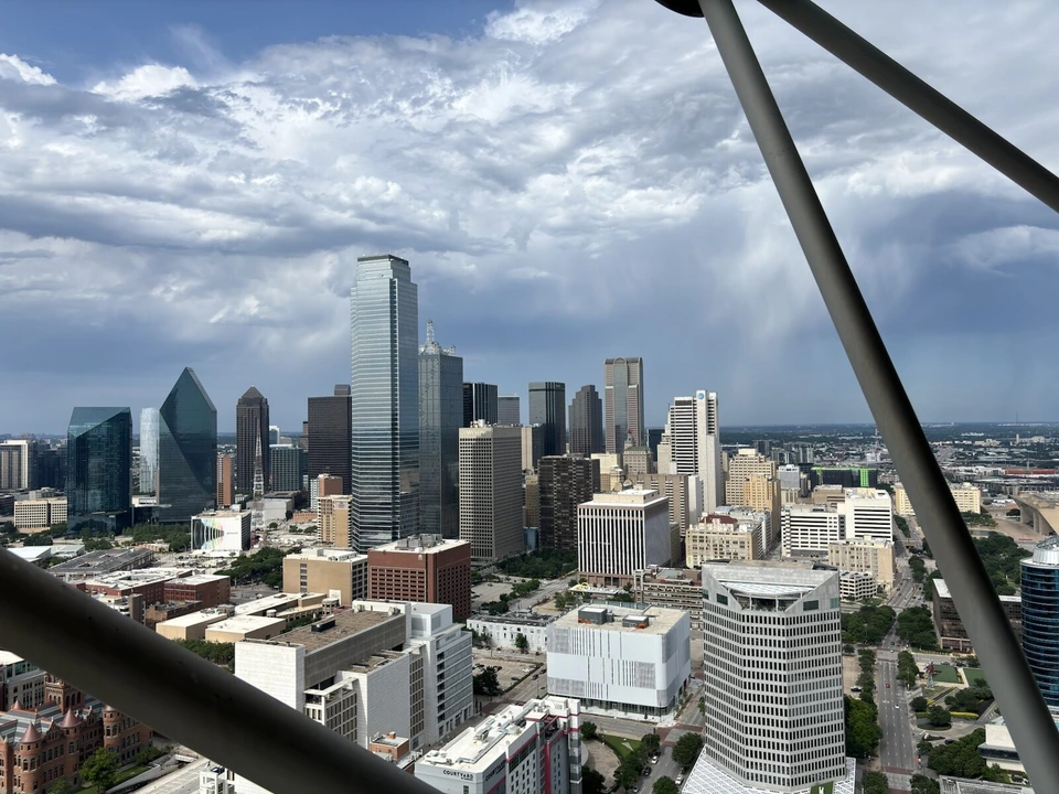 リユニオンタワーの展望台から見たダラスの高層ビル群と、遠くの雨雲