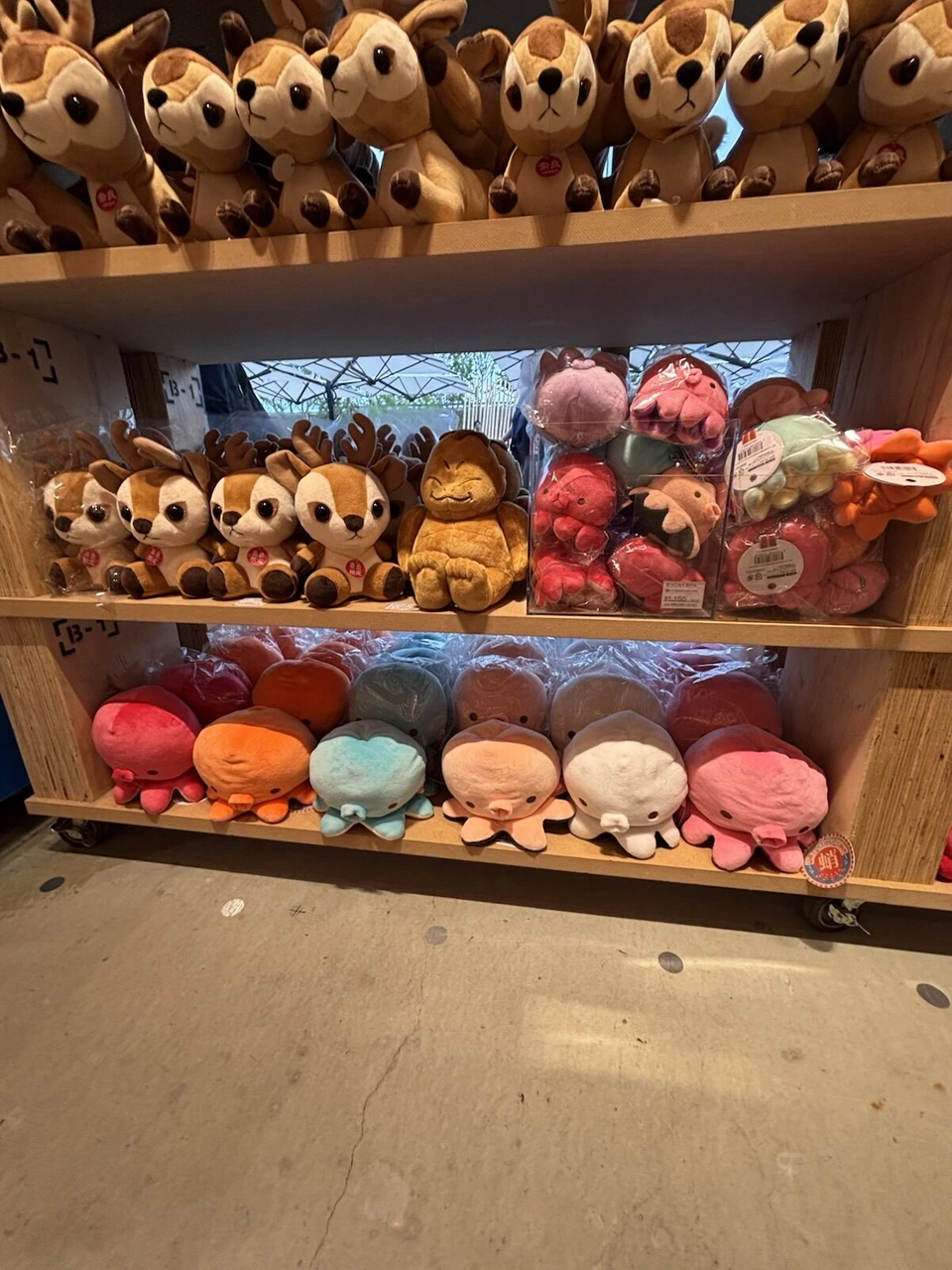 大阪・関西万博の会場内ショップの棚に並ぶ鹿とタコのぬいぐるみ