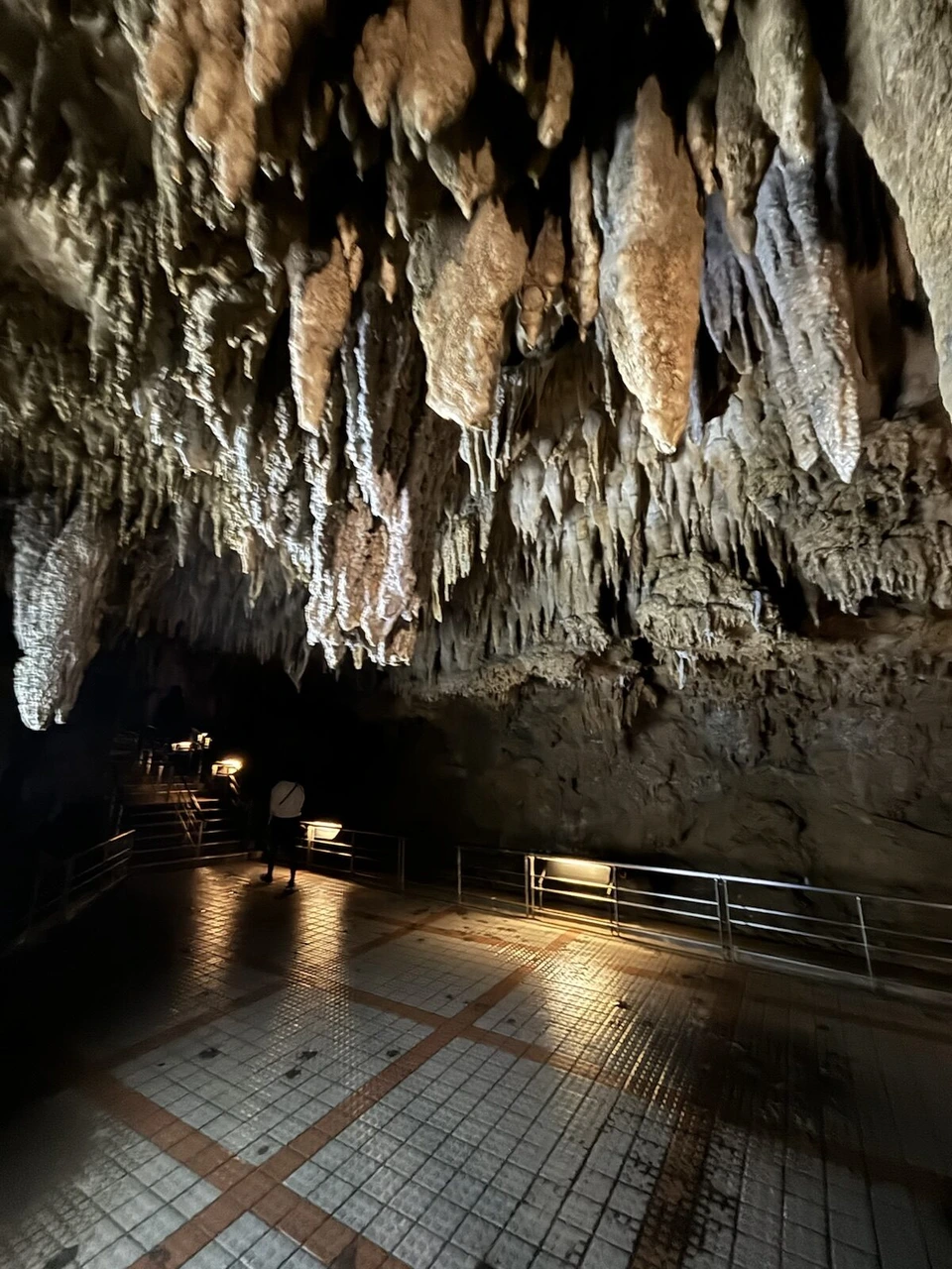玉泉洞のタイル張りの床の広い通路と、天井から下がる大きな鍾乳石