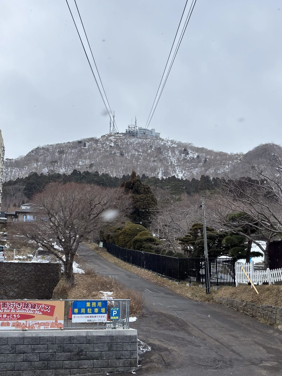 ロープウェイのケーブル越しに見上げた雪の函館山