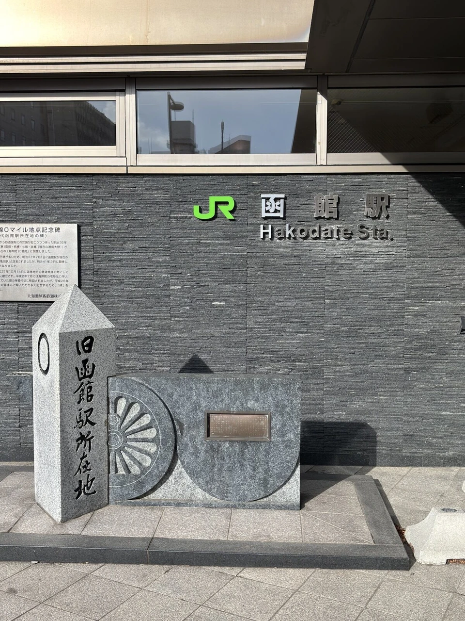 函館駅の外壁の駅名と、駅前に置かれた石碑