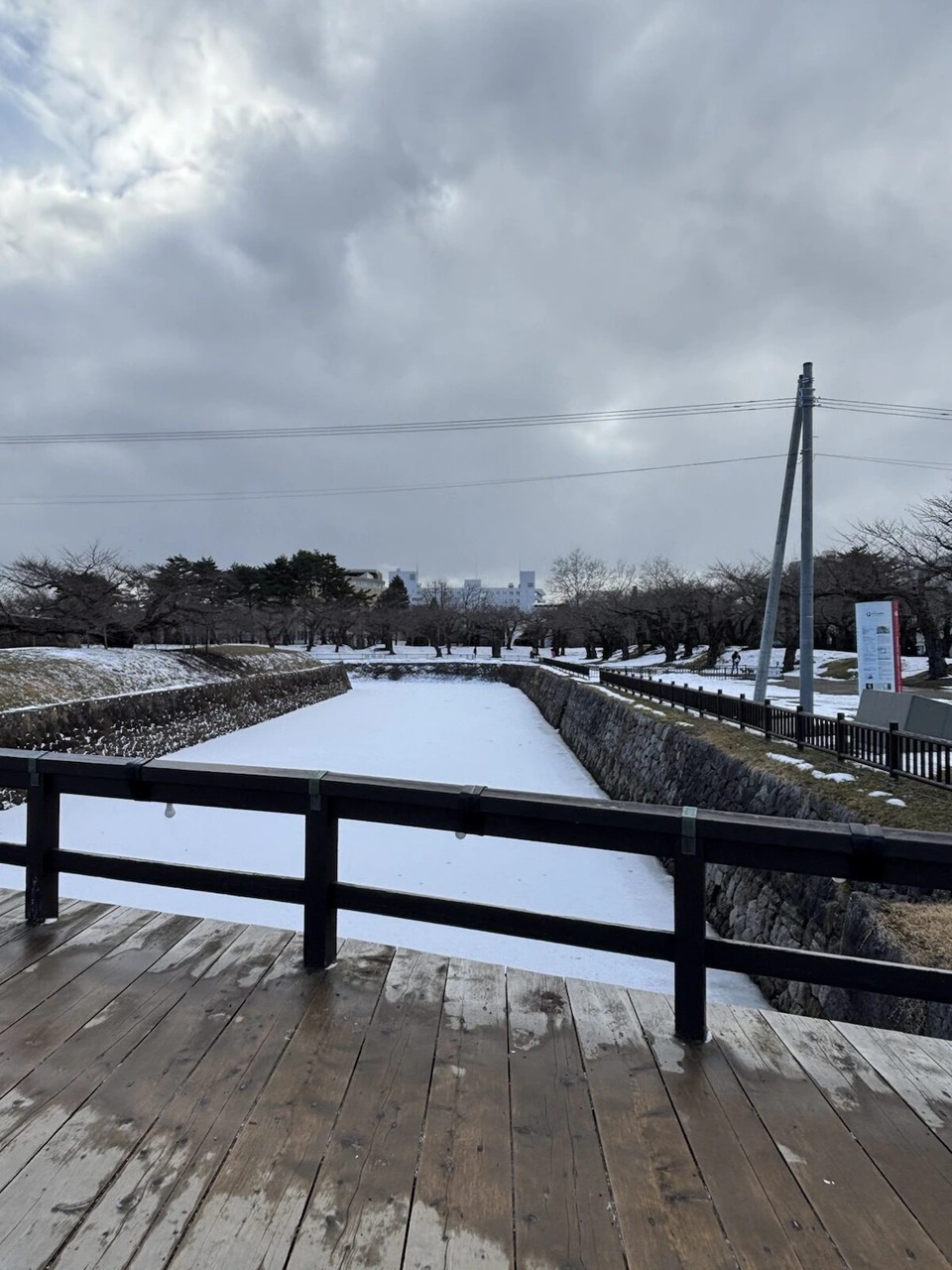 五稜郭の堀にかかる木の橋の上から見た、雪の積もった堀