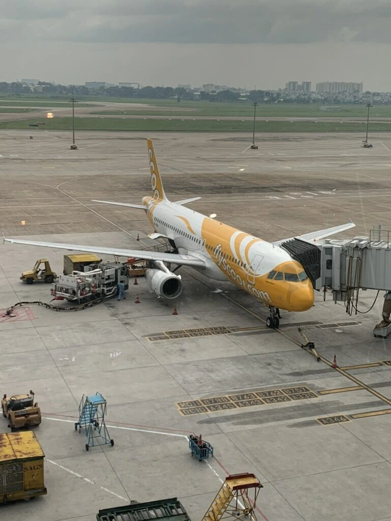 タンソンニャット空港のターミナルの窓から見たスクートのA320